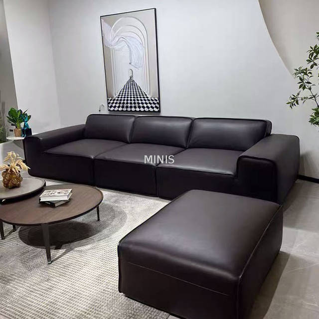 Salon agr&eacute;able canap&eacute; en cuir noir confortable avec pouf