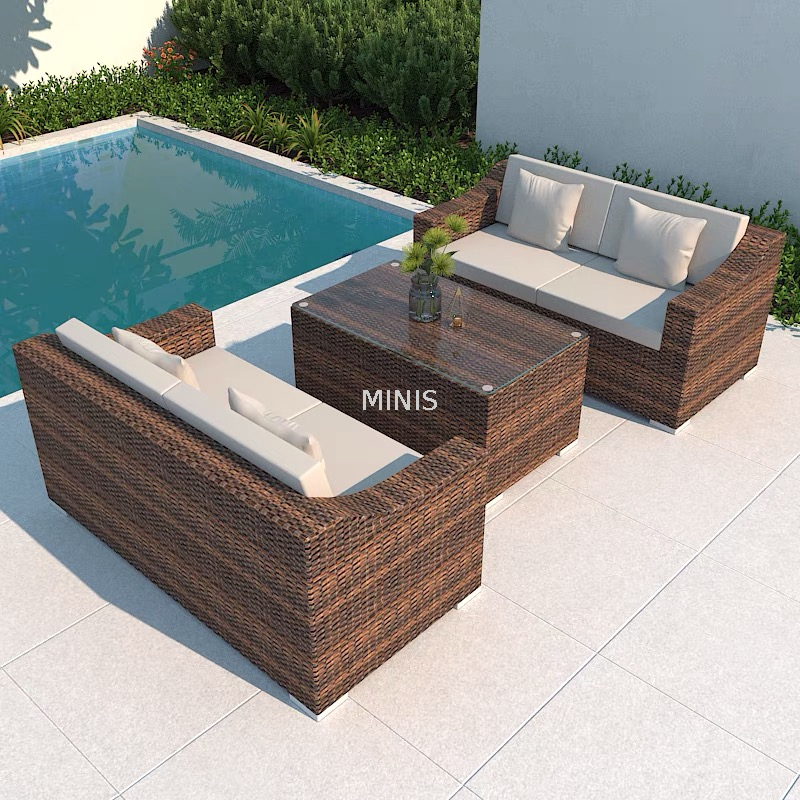 Sof&aacute; de mimbre marr&oacute;n para jard&iacute;n al aire libre con mesa de cristal